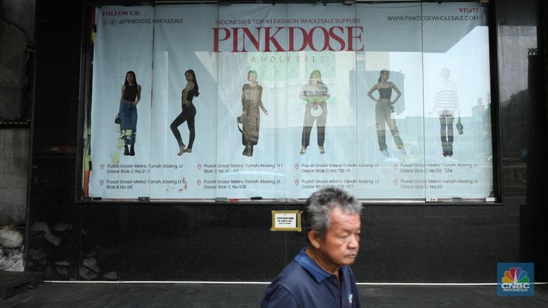 Warga melintas di depan Pasar Tanah Abang Blok A yang tutup di Jakarta, Selasa (16/4/2024). (CNBC Indonesia/Tri Susilo)