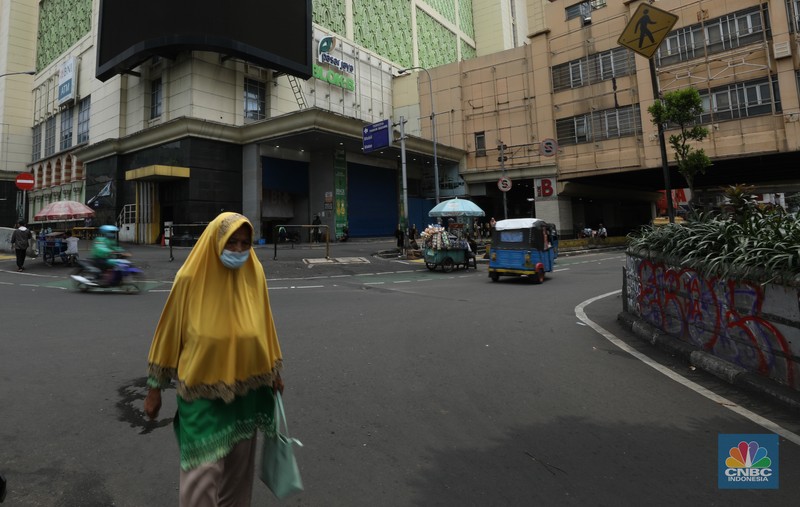 Warga melintas di depan Pasar Tanah Abang Blok A yang tutup di Jakarta, Selasa (16/4/2024). (CNBC Indonesia/Tri Susilo)