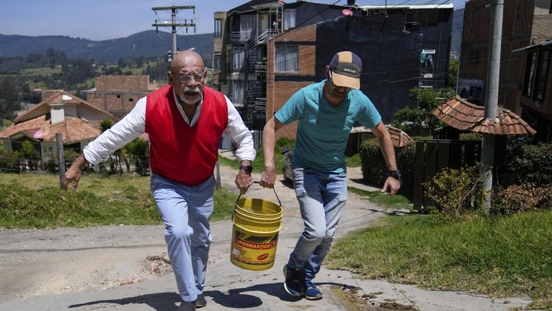 Warga mengantri untuk mengambil air dari truk saat penjatahan air di La Calera, pinggiran Bogota, Kolombia, Selasa, 16 April 2024. Di tengah kekeringan terkait pola cuaca El Niño, beberapa wilayah di Kolombia mengambil tindakan untuk mengambil air dari truk. membatasi konsumsi air ketika jumlah waduk terbatas. (AP Photo/Fernando Vergara)
