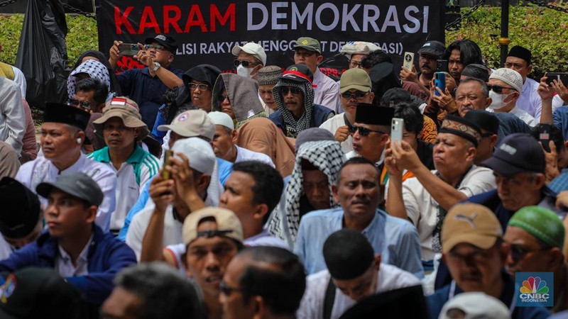 Demonstran yang tergabung dalam Koalisi Aksi Bersama melakasanakan salat Jumat di kawasan Patung Kuda, Jakarta, Jumat (19/4/2024).  (CNBC Indonesia/Faisal Rahman)