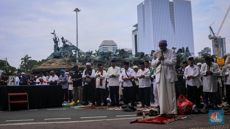 Demonstran yang tergabung dalam Koalisi Aksi Bersama melakasanakan salat Jumat di kawasan Patung Kuda, Jakarta, Jumat (19/4/2024).  (CNBC Indonesia/Faisal Rahman)