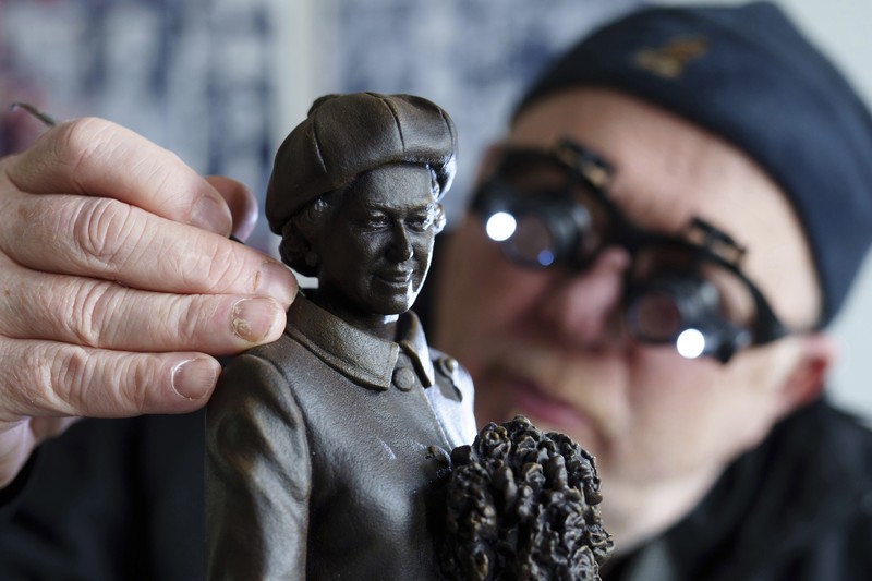 Pematung Staffordshire Andy Edwards berpose sambil menyempurnakan studi potret dengan lilin untuk patung Ratu Elizabeth II yang ditugaskan oleh Dewan Borough Newcastle-under-Lyme untuk menandai ulang tahun ke-850 wilayah tersebut, Newcastle-Under-Lyme, Inggris, Kamis, 18 April 2024. Edwards yang karya sebelumnya termasuk patung terkenal Beatles di Pier Head Liverpool, mendasarkan patung tersebut pada foto kunjungan mendiang Ratu ke Newcastle-under-Lyme sebagai bagian dari perayaan ulang tahun ke-800 Borough pada tahun 1973. (AP Photo/Jon Super)