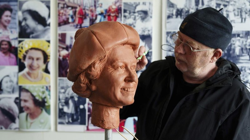 Pematung Staffordshire Andy Edwards berpose sambil menyempurnakan studi potret dengan lilin untuk patung Ratu Elizabeth II yang ditugaskan oleh Dewan Borough Newcastle-under-Lyme untuk menandai ulang tahun ke-850 wilayah tersebut, Newcastle-Under-Lyme, Inggris, Kamis, 18 April 2024. Edwards yang karya sebelumnya termasuk patung terkenal Beatles di Pier Head Liverpool, mendasarkan patung tersebut pada foto kunjungan mendiang Ratu ke Newcastle-under-Lyme sebagai bagian dari perayaan ulang tahun ke-800 Borough pada tahun 1973. (AP Photo/Jon Super)