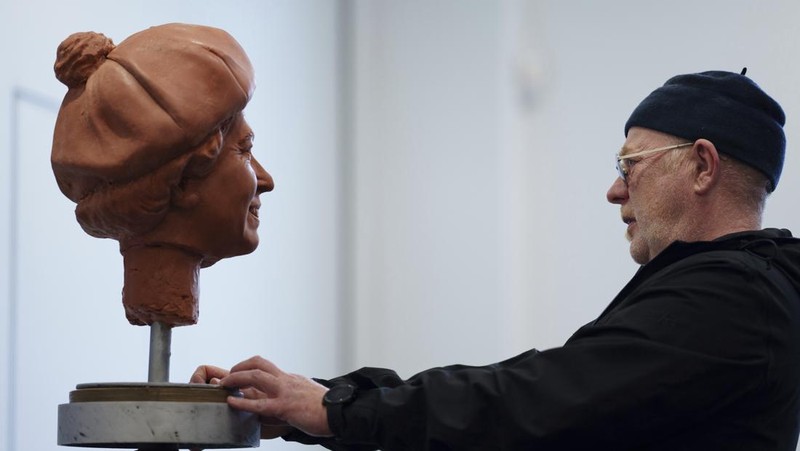 Pematung Staffordshire Andy Edwards berpose sambil menyempurnakan studi potret dengan lilin untuk patung Ratu Elizabeth II yang ditugaskan oleh Dewan Borough Newcastle-under-Lyme untuk menandai ulang tahun ke-850 wilayah tersebut, Newcastle-Under-Lyme, Inggris, Kamis, 18 April 2024. Edwards yang karya sebelumnya termasuk patung terkenal Beatles di Pier Head Liverpool, mendasarkan patung tersebut pada foto kunjungan mendiang Ratu ke Newcastle-under-Lyme sebagai bagian dari perayaan ulang tahun ke-800 Borough pada tahun 1973. (AP Photo/Jon Super)