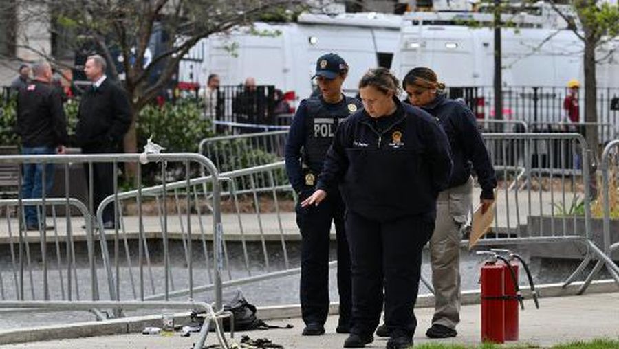 Law enforcement officials investigate the scene after a man reportedly set himself on fire in the park across from Manhattan Criminal Court during the trial of US President Donald Trump, in New York City on April 19, 2024. A man set himself on fire Friday outside the court, New York police said, with officers rushing to extinguish the flames. TV reporters described the scene that unfolded moments after the full panel of 12 jurors and six alternates was selected for the trial of the former president in a hush money cover-up case. (Photo by ANGELA WEISS / AFP)