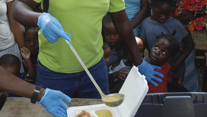 Seorang pria mengangkat rantai yang digunakan sebagai barikade agar tetangga dapat masuk ke lingkungan tersebut saat mereka bekerja menyiapkan gerbang logam untuk melindungi diri dari geng, di lingkungan Petion-Ville di Port-au-Prince, Haiti, Sabtu, 20 April , 2024. (AP Photo/Ramon Espinosa)