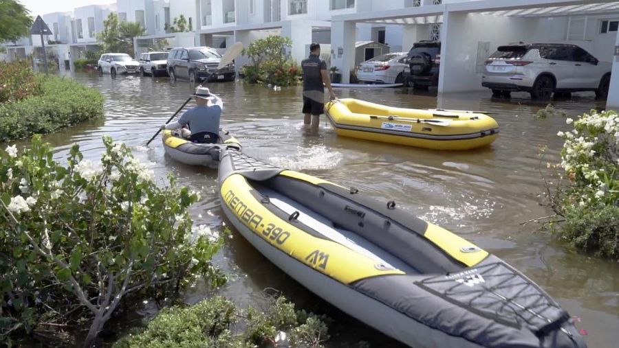 Residents canoe through the Mudon neighborhood in Dubai, United Arab Emirates, Thursday, April 18, 2024. The United Arab Emirates attempted to dry out Thursday from the heaviest rain the desert nation has ever recorded — a deluge that flooded out Dubai International Airport and disrupted flights through the world's busiest airfield for international travel. (AP Photo/Jon Gambrell)