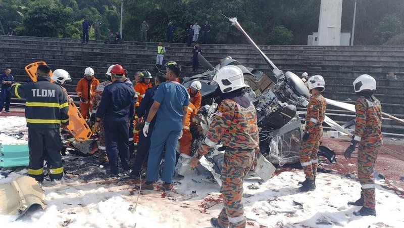 Dalam foto yang dirilis Departemen Pemadam Kebakaran & Penyelamatan Malaysia, departemen pemadam kebakaran dan penyelamatan memeriksa lokasi jatuhnya dua helikopter di Lumur, negara bagian Perak, Senin, 23 April 2024. Angkatan Laut Malaysia mengatakan dua helikopter militer bertabrakan dan jatuh saat sesi latihan, membunuh 10 orang di dalamnya. (Terence Tan/Ministry of Communications and Information via AP)