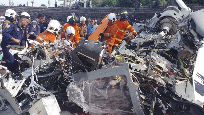 Dalam foto yang dirilis Departemen Pemadam Kebakaran & Penyelamatan Malaysia, departemen pemadam kebakaran dan penyelamatan memeriksa lokasi jatuhnya dua helikopter di Lumur, negara bagian Perak, Senin, 23 April 2024. Angkatan Laut Malaysia mengatakan dua helikopter militer bertabrakan dan jatuh saat sesi latihan, membunuh 10 orang di dalamnya. (Terence Tan/Ministry of Communications and Information via AP)