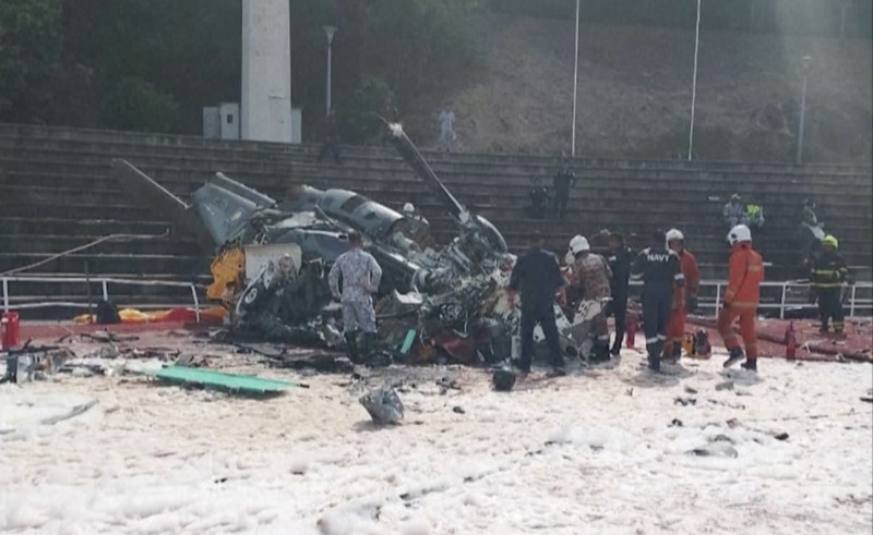 Dalam foto yang dirilis Departemen Pemadam Kebakaran & Penyelamatan Malaysia, departemen pemadam kebakaran dan penyelamatan memeriksa lokasi jatuhnya dua helikopter di Lumur, negara bagian Perak, Senin, 23 April 2024. Angkatan Laut Malaysia mengatakan dua helikopter militer bertabrakan dan jatuh saat sesi latihan, membunuh 10 orang di dalamnya. (Terence Tan/Ministry of Communications and Information via AP)