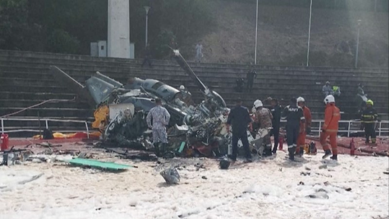 Dalam foto yang dirilis Departemen Pemadam Kebakaran & Penyelamatan Malaysia, departemen pemadam kebakaran dan penyelamatan memeriksa lokasi jatuhnya dua helikopter di Lumur, negara bagian Perak, Senin, 23 April 2024. Angkatan Laut Malaysia mengatakan dua helikopter militer bertabrakan dan jatuh saat sesi latihan, membunuh 10 orang di dalamnya. (Terence Tan/Ministry of Communications and Information via AP)