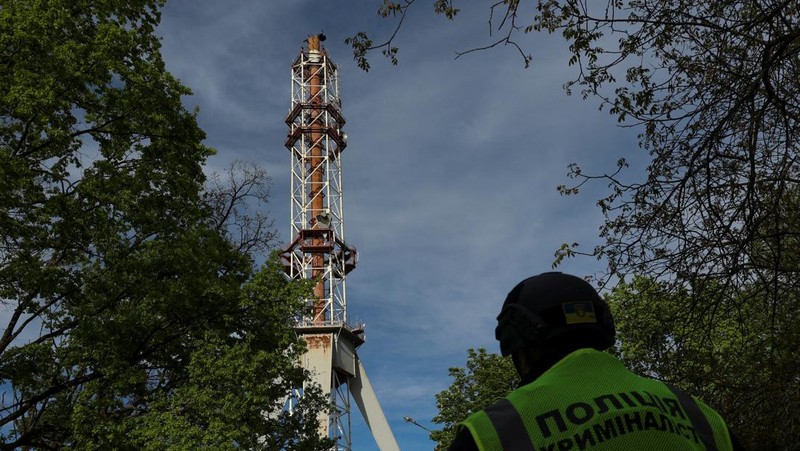 Petugas polisi berdiri di samping bagian menara televisi yang sebagian hancur akibat serangan rudal Rusia, di tengah serangan Rusia ke Ukraina, di Kharkiv, Ukraina 22 April 2024. (REUTERS/Sofiia Gatilova)