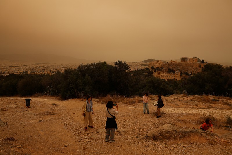 Warga mengabadikan momen gelombang debu yang tertiup angin dari gurun Sahara menutupi Athena dan kota-kota Yunani lainnya pada Selasa, (23/4/2024) waktu setempat. (AP Photo/Petros Giannakouris) Warga mengabadikan momen gelombang debu yang tertiup angin dari gurun Sahara menutupi Athena dan kota-kota Yunani lainnya pada Selasa, (23/4/2024) waktu setempat. (AP Photo/Petros Giannakouris)