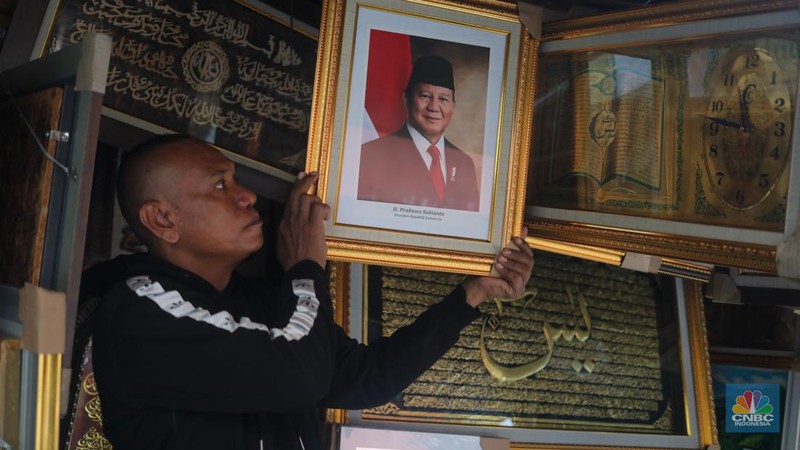 Penjual menata pigura foto Presiden dan Wakil Presiden terpilih periode 2024-2029 Prabowo Subianto dan Gibran Rakabuming Raka di kawasan Pasar Baru, Jakarta, Kamis (25/4/2024). (CNBC Indonesia/Faisal Rahman)
