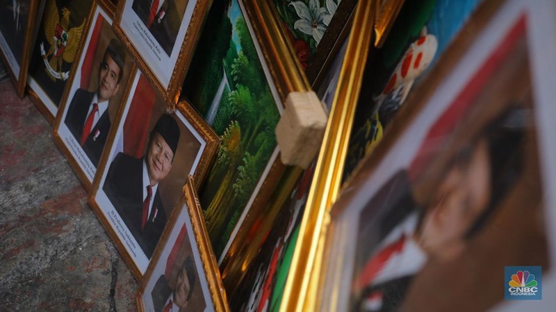 Penjual menata pigura foto Presiden dan Wakil Presiden terpilih periode 2024-2029 Prabowo Subianto dan Gibran Rakabuming Raka di kawasan Pasar Baru, Jakarta, Kamis (25/4/2024). (CNBC Indonesia/Faisal Rahman)