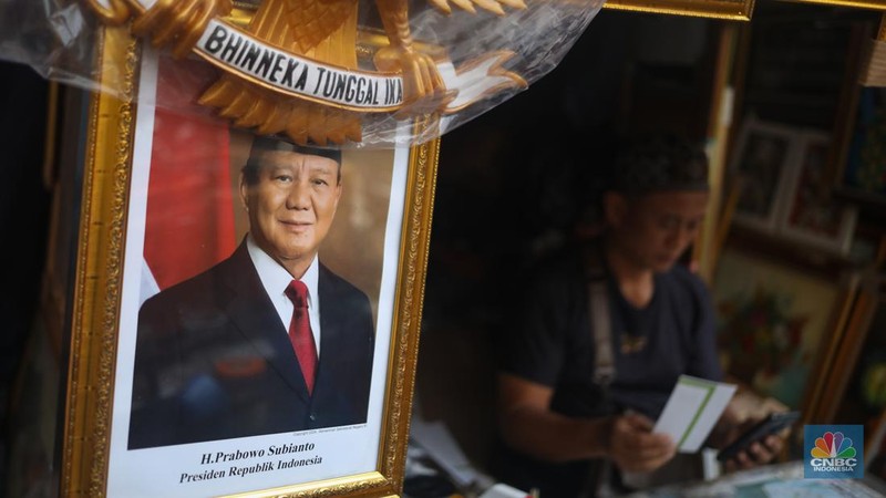 Penjual menata pigura foto Presiden dan Wakil Presiden terpilih periode 2024-2029 Prabowo Subianto dan Gibran Rakabuming Raka di kawasan Pasar Baru, Jakarta, Kamis (25/4/2024). (CNBC Indonesia/Faisal Rahman)