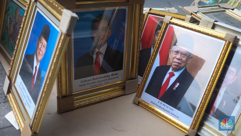 Penjual menata pigura foto Presiden dan Wakil Presiden terpilih periode 2024-2029 Prabowo Subianto dan Gibran Rakabuming Raka di kawasan Pasar Baru, Jakarta, Kamis (25/4/2024). (CNBC Indonesia/Faisal Rahman)