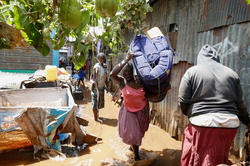 Warga beristirahat di atas rumah mereka menunggu bantuan penyelamatan setelah Sungai Athi meluap dan membuat rumah mereka terdampar menyusul hujan lebat di pemukiman Kwa Mang'eli di daerah Machakos dekat Nairobi, Kenya 24 April 2024. (REUTERS/Thomas Mukoya)