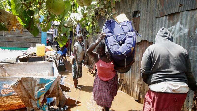 Warga beristirahat di atas rumah mereka menunggu bantuan penyelamatan setelah Sungai Athi meluap dan membuat rumah mereka terdampar menyusul hujan lebat di pemukiman Kwa Mang'eli di daerah Machakos dekat Nairobi, Kenya 24 April 2024. (REUTERS/Thomas Mukoya)