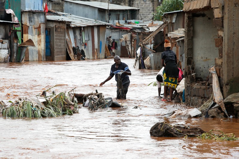 Warga beristirahat di atas rumah mereka menunggu bantuan penyelamatan setelah Sungai Athi meluap dan membuat rumah mereka terdampar menyusul hujan lebat di pemukiman Kwa Mang'eli di daerah Machakos dekat Nairobi, Kenya 24 April 2024. (REUTERS/Thomas Mukoya)