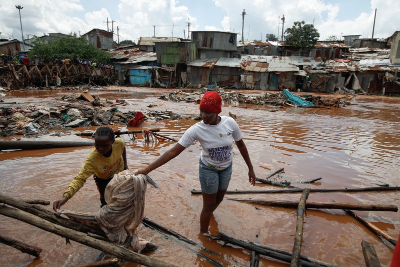 Warga beristirahat di atas rumah mereka menunggu bantuan penyelamatan setelah Sungai Athi meluap dan membuat rumah mereka terdampar menyusul hujan lebat di pemukiman Kwa Mang'eli di daerah Machakos dekat Nairobi, Kenya 24 April 2024. (REUTERS/Thomas Mukoya)