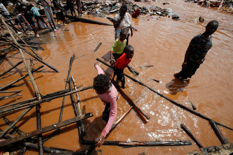 Warga beristirahat di atas rumah mereka menunggu bantuan penyelamatan setelah Sungai Athi meluap dan membuat rumah mereka terdampar menyusul hujan lebat di pemukiman Kwa Mang'eli di daerah Machakos dekat Nairobi, Kenya 24 April 2024. (REUTERS/Thomas Mukoya)