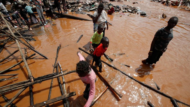 Warga beristirahat di atas rumah mereka menunggu bantuan penyelamatan setelah Sungai Athi meluap dan membuat rumah mereka terdampar menyusul hujan lebat di pemukiman Kwa Mang'eli di daerah Machakos dekat Nairobi, Kenya 24 April 2024. (REUTERS/Thomas Mukoya)