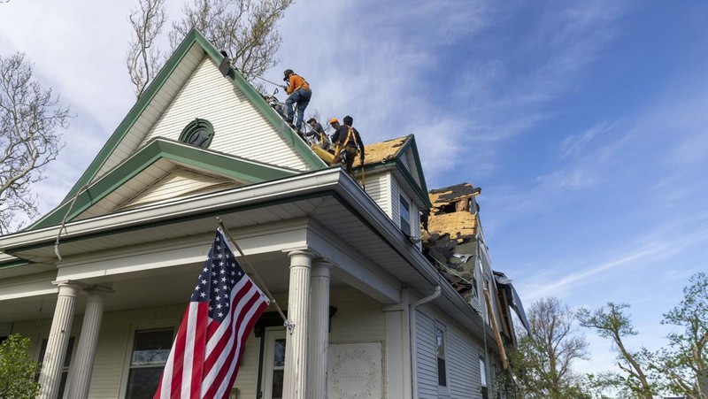 Penghuni rumah membersihkan puing-puing bangunan yang rusak pasca tornado di Omaha, Nebraska, AS, 26 April 2024. (Nikos Frazier/Omaha World-Herald via AP)