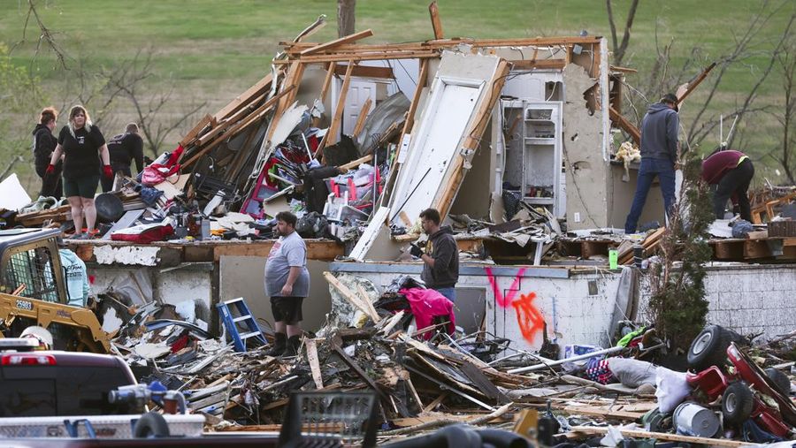 Penghuni rumah membersihkan puing-puing bangunan yang rusak pasca tornado di Omaha, Nebraska, AS, 26 April 2024. (Nikos Frazier/Omaha World-Herald via AP)
