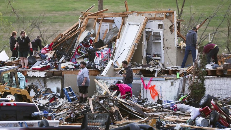 Penghuni rumah membersihkan puing-puing bangunan yang rusak pasca tornado di Omaha, Nebraska, AS, 26 April 2024. (Nikos Frazier/Omaha World-Herald via AP)