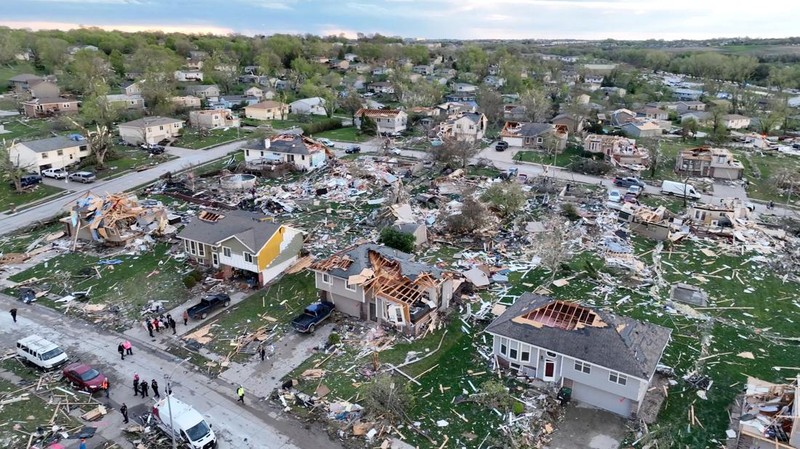 Penghuni rumah membersihkan puing-puing bangunan yang rusak pasca tornado di Omaha, Nebraska, AS, 26 April 2024. (Nikos Frazier/Omaha World-Herald via AP)