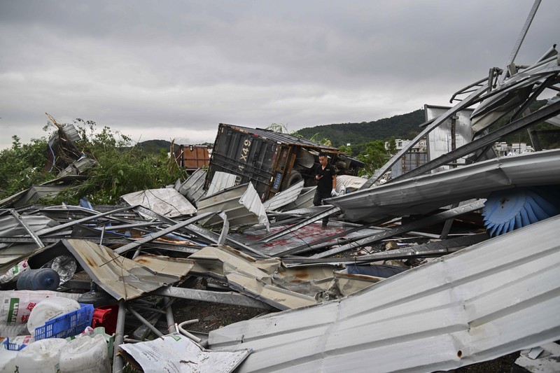 Seorang warga mendokumentasikan detik-detik bencana alam angin tornado melanda Guangzhou, ibu kota provinsi Guangdong, Sabtu 27 April 2024, terekam kamera. (AP/Li Jiayi)