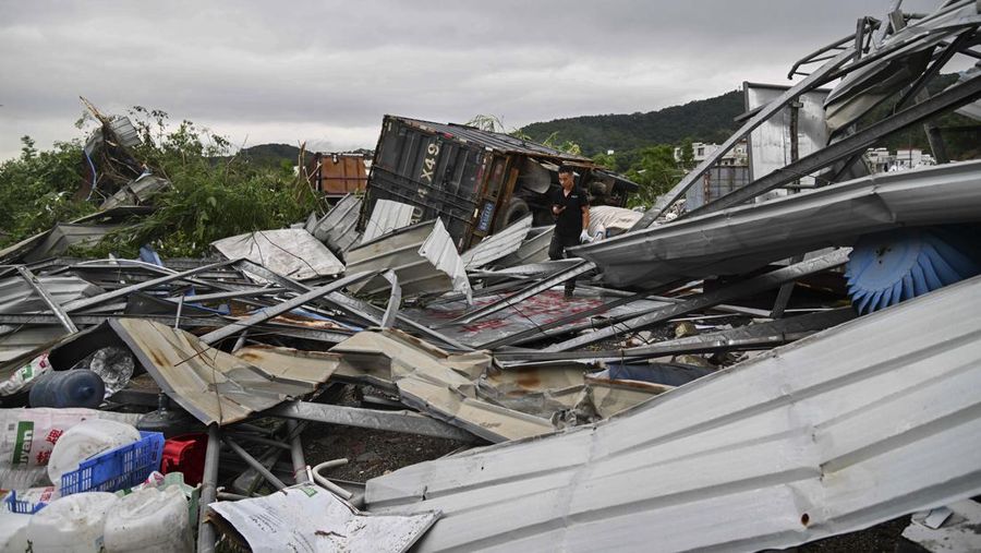 Seorang warga mendokumentasikan detik-detik bencana alam angin tornado melanda Guangzhou, ibu kota provinsi Guangdong, Sabtu 27 April 2024, terekam kamera. (AP/Li Jiayi)