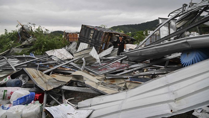 Seorang warga mendokumentasikan detik-detik bencana alam angin tornado melanda Guangzhou, ibu kota provinsi Guangdong, Sabtu 27 April 2024, terekam kamera. (AP/Li Jiayi)