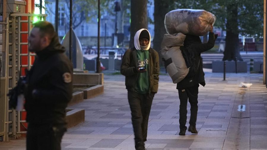 Seorang migran mengemas barang-barangnya di kamp darurat, Selasa dini hari, 23 April 2024 di Paris. Petugas polisi Prancis telah mengusir para migran dari kamp darurat di Paris yang berjarak beberapa langkah dari Sungai Seine, karena operasi serupa telah dilakukan oleh pihak berwenang menjelang Olimpiade. (AP Photo/Nicolas Garriga)