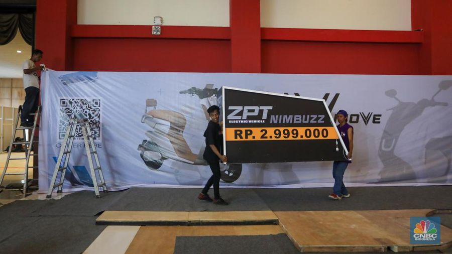 Pekerja menyelesaikan pembuatan tenant jelang berlangsungnya acara Periklindo Electric Vehicle Show (PEVS) di JIExpo Kemayoran, Jakarta, Senin (29/4/2024). (CNBC Indonesia/Faisal Rahman)