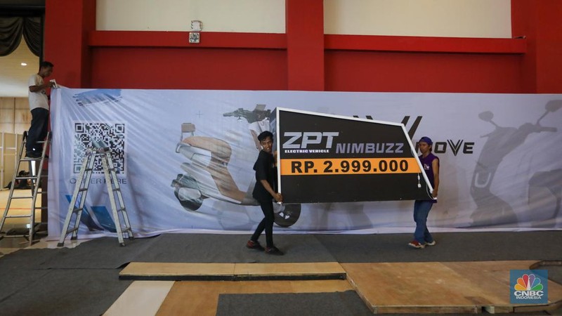 Pekerja menyelesaikan pembuatan tenant jelang berlangsungnya acara Periklindo Electric Vehicle Show (PEVS) di JIExpo Kemayoran, Jakarta, Senin (29/4/2024). (CNBC Indonesia/Faisal Rahman)