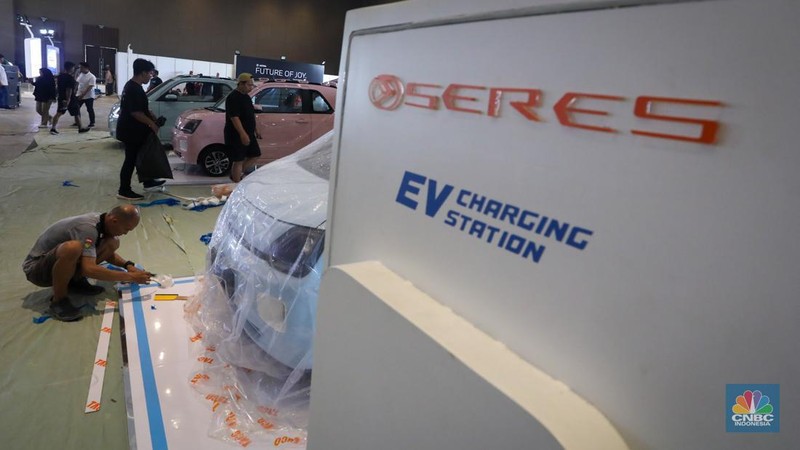 Pekerja menyelesaikan pembuatan tenant jelang berlangsungnya acara Periklindo Electric Vehicle Show (PEVS) di JIExpo Kemayoran, Jakarta, Senin (29/4/2024). (CNBC Indonesia/Faisal Rahman)