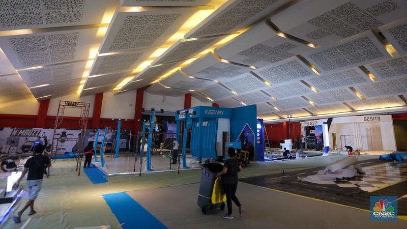 Pekerja menyelesaikan pembuatan tenant jelang berlangsungnya acara Periklindo Electric Vehicle Show (PEVS) di JIExpo Kemayoran, Jakarta, Senin (29/4/2024). (CNBC Indonesia/Faisal Rahman)
