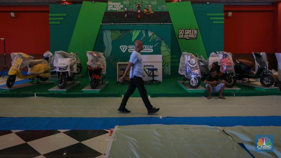 Pekerja menyelesaikan pembuatan tenant jelang berlangsungnya acara Periklindo Electric Vehicle Show (PEVS) di JIExpo Kemayoran, Jakarta, Senin (29/4/2024). (CNBC Indonesia/Faisal Rahman)