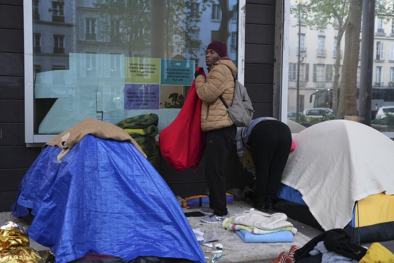 Seorang migran mengemas barang-barangnya di kamp darurat, Selasa dini hari, 23 April 2024 di Paris. Seorang migran mengemas barang-barangnya di kamp darurat, Selasa dini hari, 23 April 2024 di Paris. Petugas polisi Prancis telah mengusir para migran dari kamp darurat di Paris yang berjarak beberapa langkah dari Sungai Seine, karena operasi serupa telah dilakukan oleh pihak berwenang menjelang Olimpiade. (AP Photo/Nicolas Garriga)
