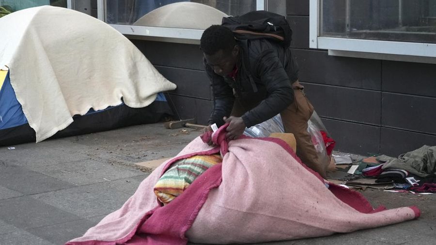 Seorang migran mengemas barang-barangnya di kamp darurat, Selasa dini hari, 23 April 2024 di Paris. Petugas polisi Prancis telah mengusir para migran dari kamp darurat di Paris yang berjarak beberapa langkah dari Sungai Seine, karena operasi serupa telah dilakukan oleh pihak berwenang menjelang Olimpiade. (AP Photo/Nicolas Garriga)