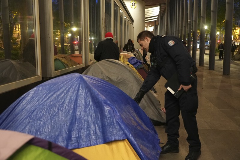 Seorang migran mengemas barang-barangnya di kamp darurat, Selasa dini hari, 23 April 2024 di Paris. Petugas polisi Prancis telah mengusir para migran dari kamp darurat di Paris yang berjarak beberapa langkah dari Sungai Seine, karena operasi serupa telah dilakukan oleh pihak berwenang menjelang Olimpiade. (AP Photo/Nicolas Garriga)