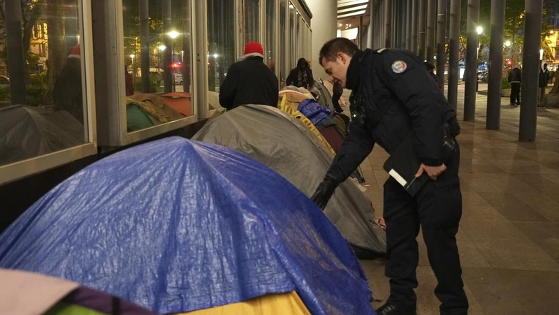 Seorang migran mengemas barang-barangnya di kamp darurat, Selasa dini hari, 23 April 2024 di Paris. Petugas polisi Prancis telah mengusir para migran dari kamp darurat di Paris yang berjarak beberapa langkah dari Sungai Seine, karena operasi serupa telah dilakukan oleh pihak berwenang menjelang Olimpiade. (AP Photo/Nicolas Garriga)