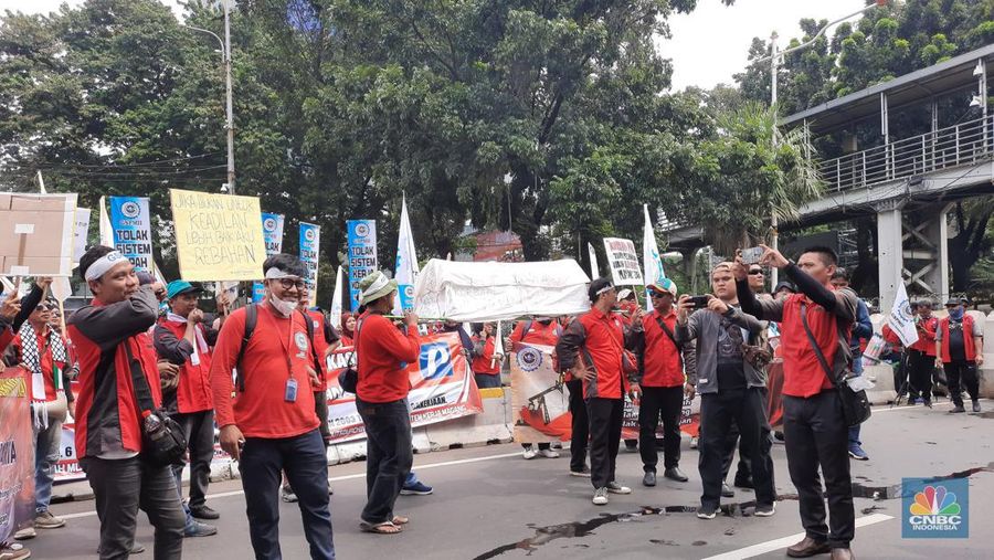 Sejumlah buruh yang akan melakukan aksi unjuk rasa memperingati May Day terlihat membawa keranda mayat di kawasan Patung Kuda, Monas, Jakarta, Rabu (1/5/2024). (CNBC Indonesia/Thea Fathanah)