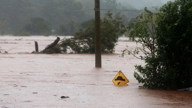 Orang-orang menyelamatkan barang-barang mereka di daerah banjir di sebelah Sungai Taquari saat hujan lebat di kota Encantado di Rio Grande do Sul, Brasil, 1 Mei 2024. (REUTERS/Diego Vara)