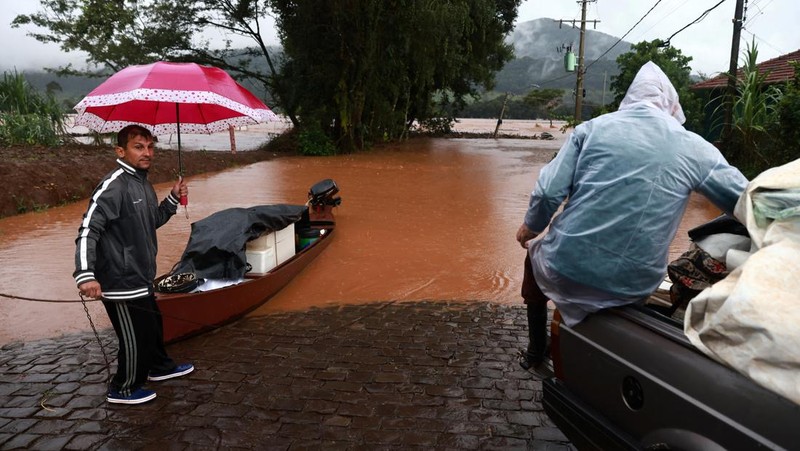 Orang-orang menyelamatkan barang-barang mereka di daerah banjir di sebelah Sungai Taquari saat hujan lebat di kota Encantado di Rio Grande do Sul, Brasil, 1 Mei 2024. (REUTERS/Diego Vara)