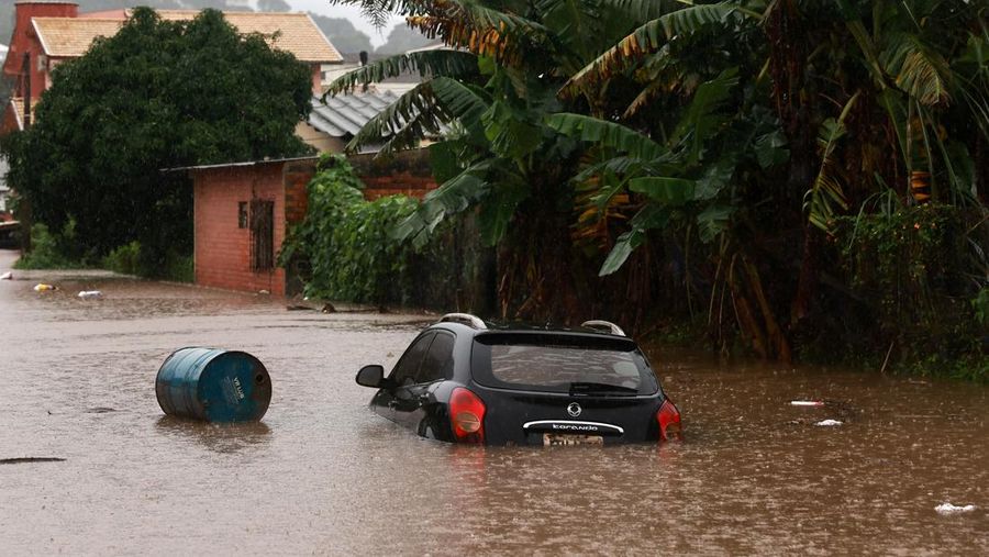 Orang-orang menyelamatkan barang-barang mereka di daerah banjir di sebelah Sungai Taquari saat hujan lebat di kota Encantado di Rio Grande do Sul, Brasil, 1 Mei 2024. (REUTERS/Diego Vara)