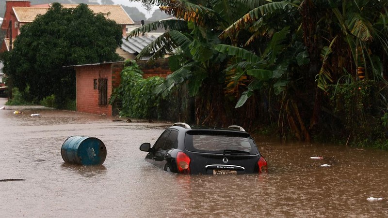 Orang-orang menyelamatkan barang-barang mereka di daerah banjir di sebelah Sungai Taquari saat hujan lebat di kota Encantado di Rio Grande do Sul, Brasil, 1 Mei 2024. (REUTERS/Diego Vara)