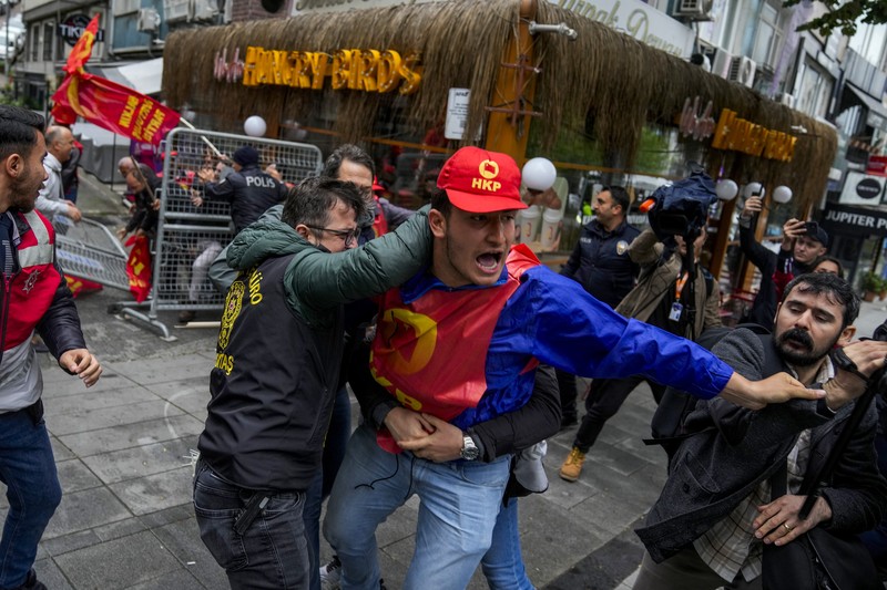 Anggota serikat pekerja bentrok dengan petugas polisi anti huru hara Turki saat mereka berbaris saat perayaan Hari Buruh di Istanbul, Turki, Rabu, 1 Mei 2024. Anggota serikat pekerja bentrok dengan petugas polisi anti huru hara Turki saat mereka berbaris saat perayaan Hari Buruh di Istanbul, Turki, Rabu, 1 Mei 2024. Polisi di Istanbul menggunakan gas air mata dan menembakkan peluru karet untuk membubarkan ribuan orang yang berusaha menerobos barikade dan mencapai alun-alun utama kota, Taksim, yang bertentangan dengan larangan pemerintah untuk merayakan Hari Buruh 1 Mei di lokasi penting tersebut. (AP Photo/Emrah Gurel)